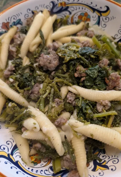 Garganelli and broccoli rabe with Italian sausage in a decorated bowl