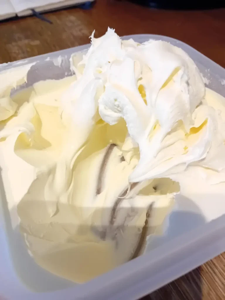 Thick, creamy homemade mascarpone piled in a plastic container