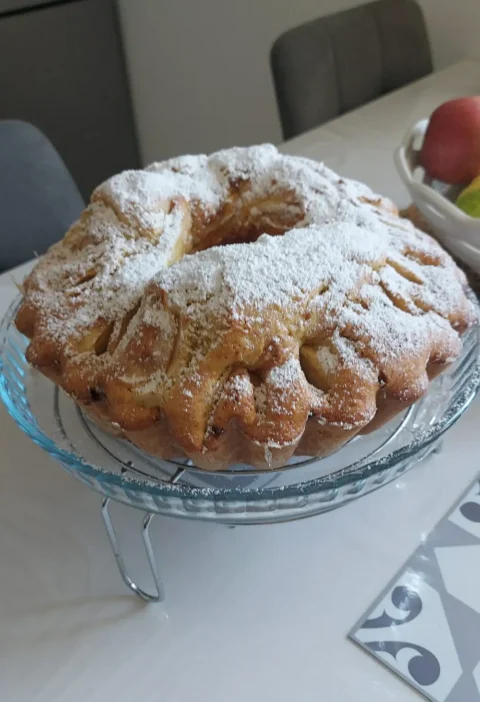Italian apple bundt cake (torta di mele) dusted with powdered sugar on a glass cake stand