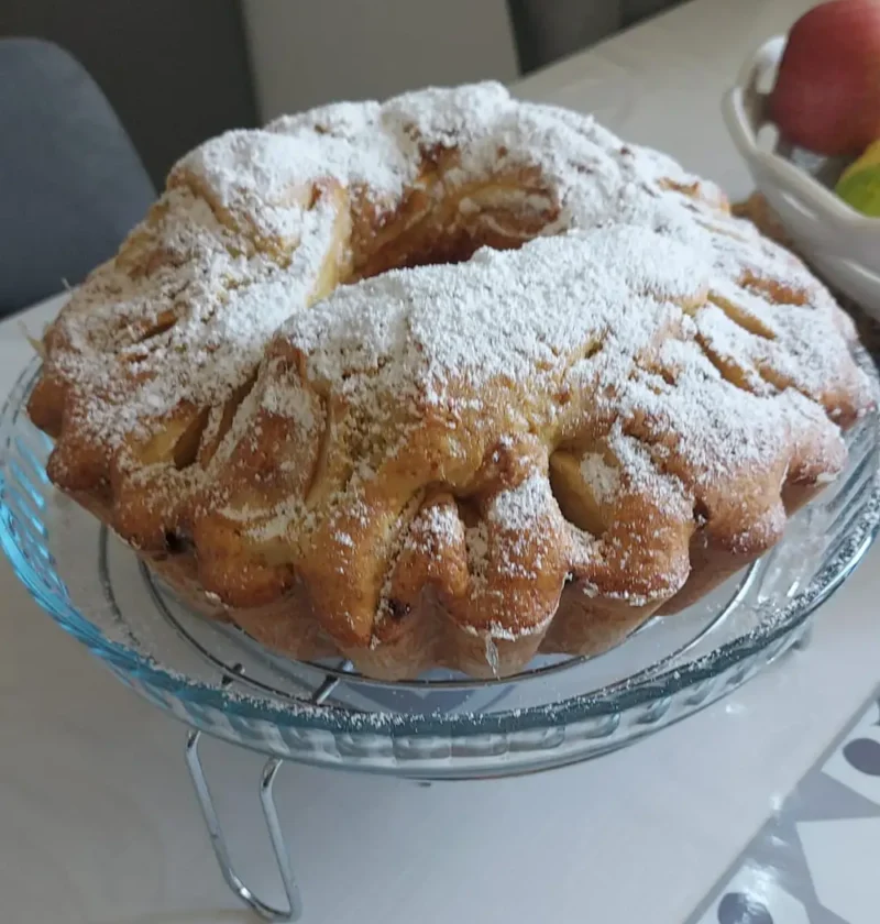 Italian apple bundt cake (torta di mele) dusted with powdered sugar on a glass cake stand
