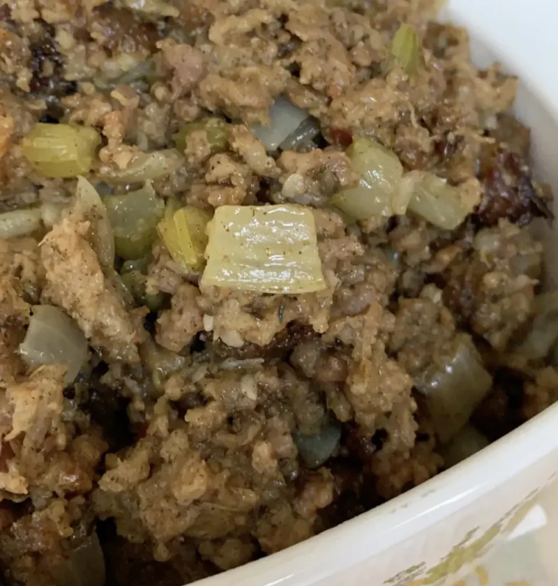 Italian sausage stuffing with celery and onion in a white baking dish