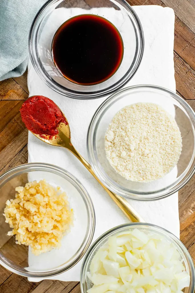 Tamari, tomato paste, almond flour, minced garlic and diced onion in small bowls
