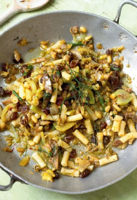Macaroni with sardines, fennel, raisins and pine nuts in a large metal skillet