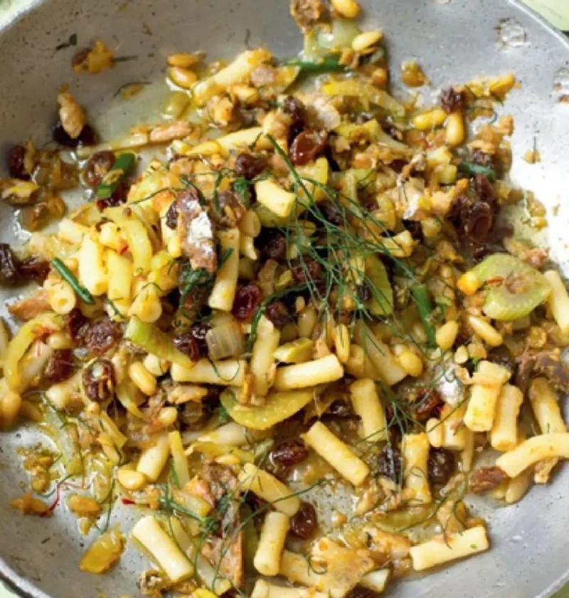 Macaroni with sardines, fennel, raisins and pine nuts in a large metal skillet