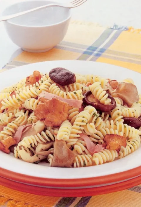 Pasta for All Seasons: fusilli with shiitake, oyster and chanterelle mushrooms and smoked ham on a white plate