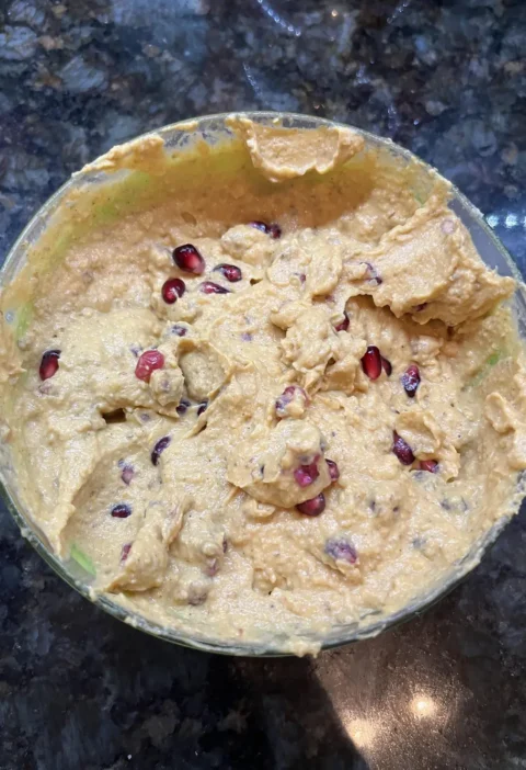 Pumpkin ricotta dip in a glass bowl, swirled and topped with pomegranate seeds
