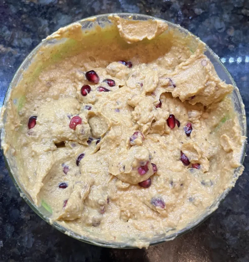Pumpkin ricotta dip in a glass bowl, swirled and topped with pomegranate seeds