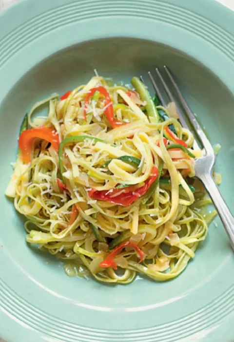 Straw and Hay with Zucchini and Pecorino: white and green tagliatelle with zucchini on a green plate