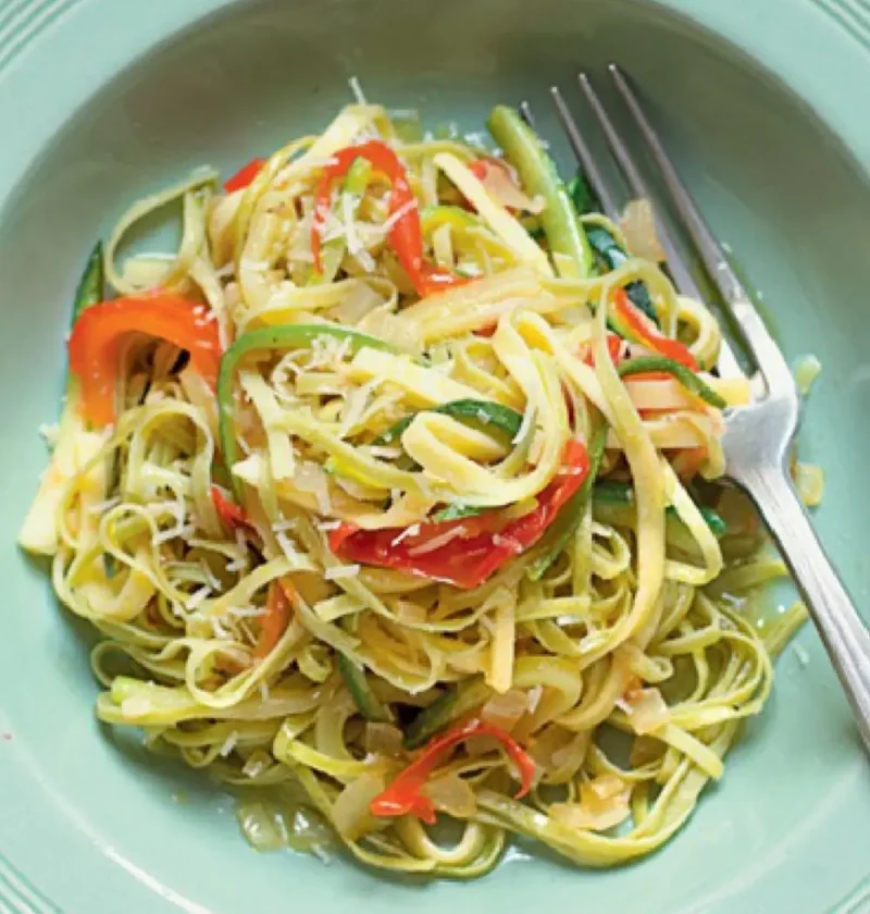 Straw and Hay with Zucchini and Pecorino: white and green tagliatelle with zucchini on a green plate